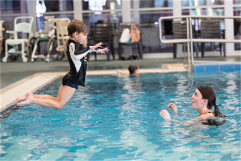 Child jumping into pool